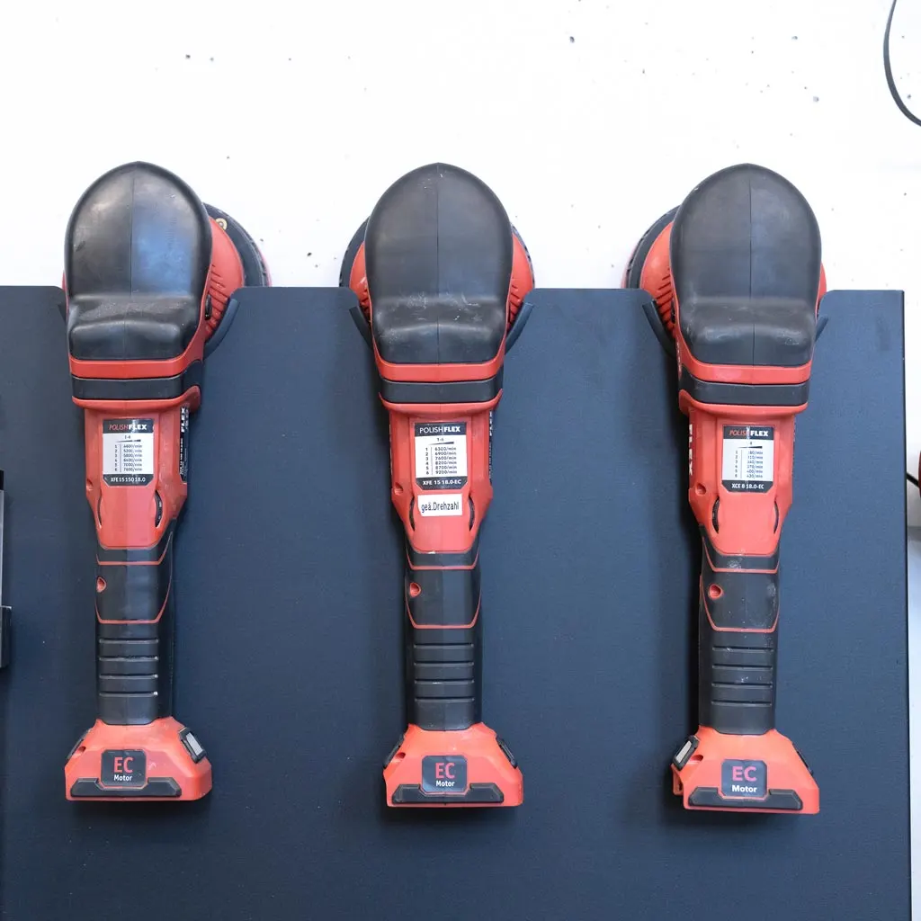 Drei rote Poliermaschinen nebeneinander an der Wand