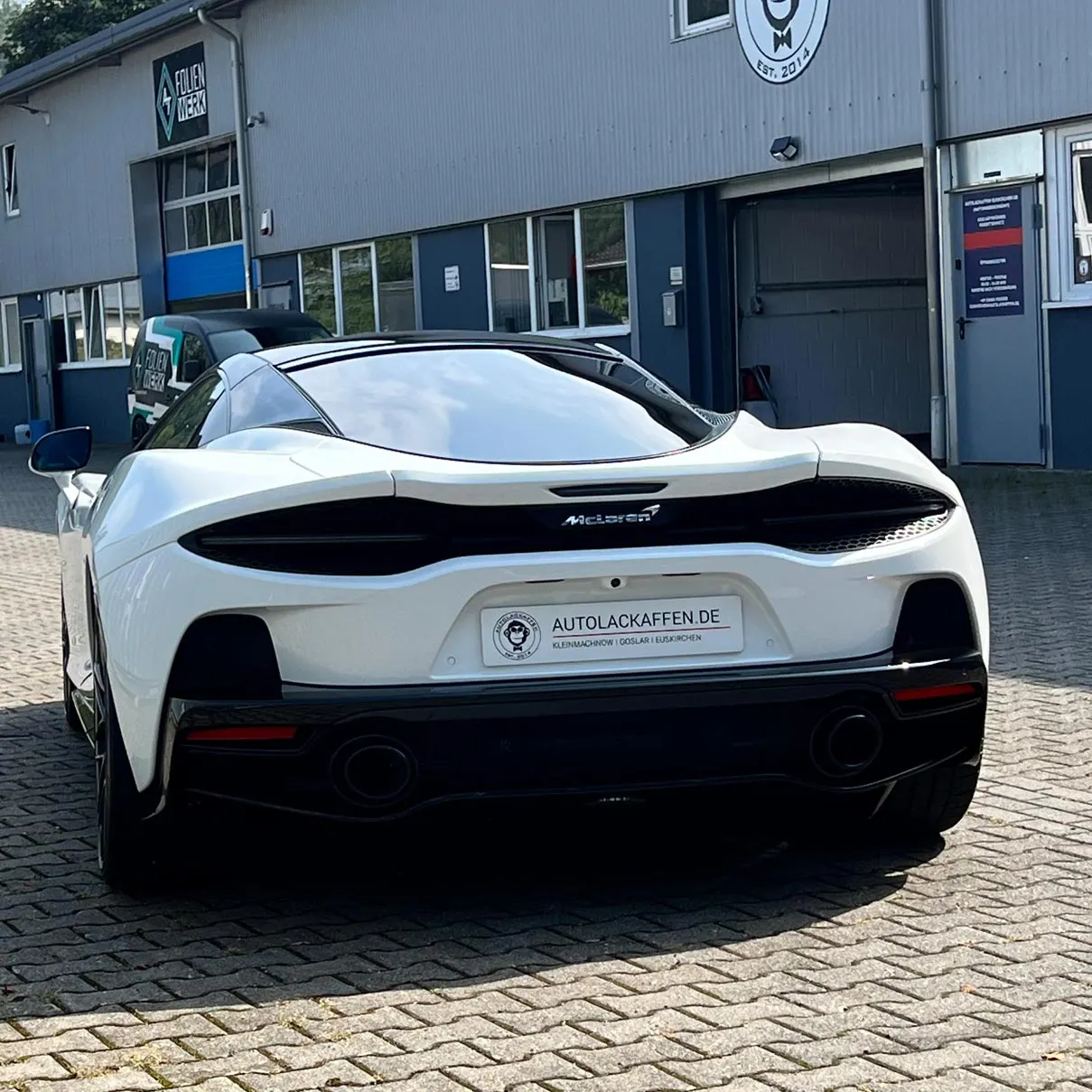 Weißer McLaren vor der Halle