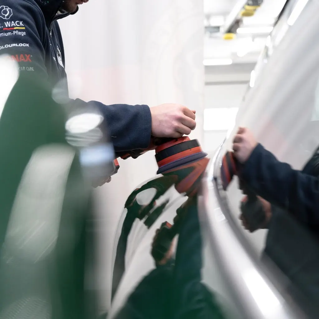Maschinenpolitur auf dem grünen Lack eines Porsche