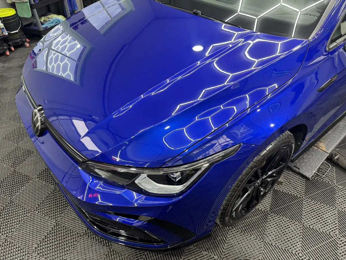 Blauer VW Golf nach der Aufbereitung in der Halle