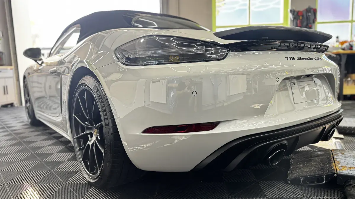 Weißer Porsche 718 Boxster nach der Lackaufbereitung in der Halle