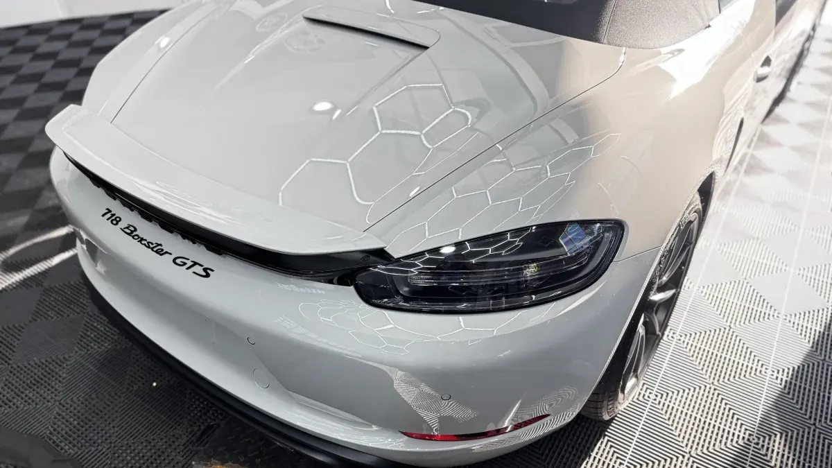 Frisch polierte Front eines weißen Porsche unter den Hallenleuchten