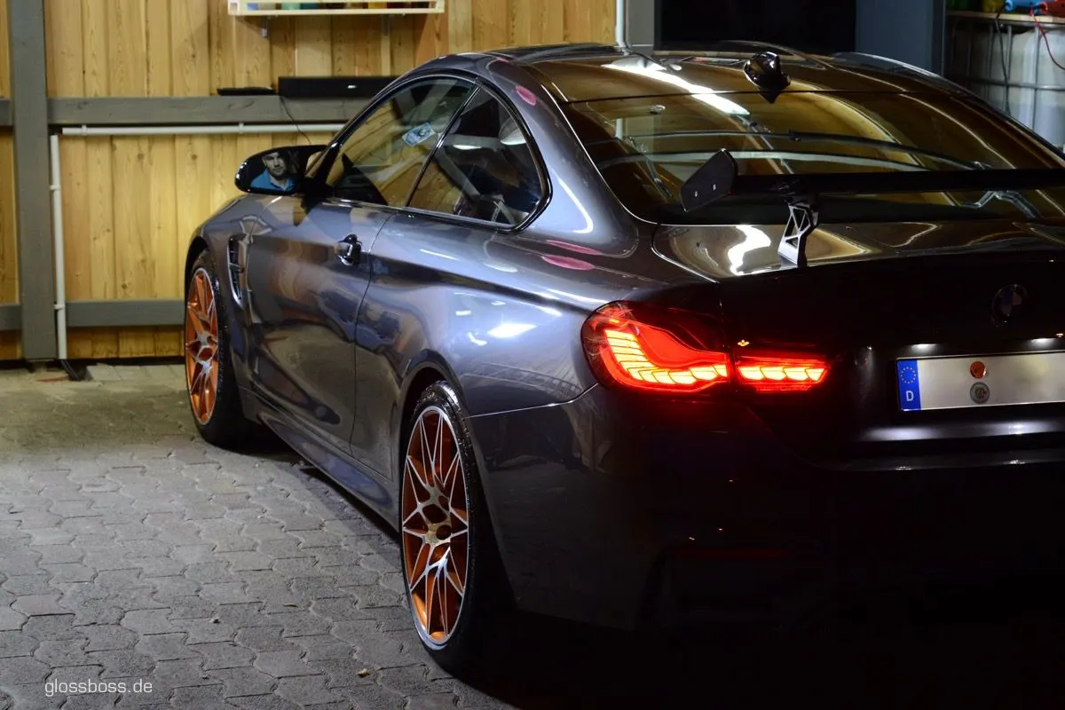 Grey coupe with lit taillights, clean and glossy after a full detail