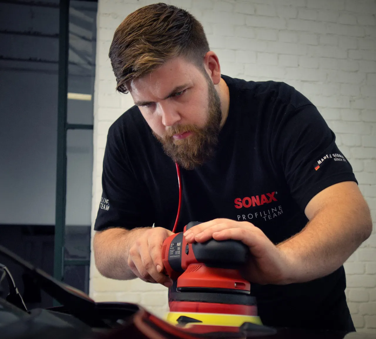 Matthias Spillmann poliert eine Motorhaube